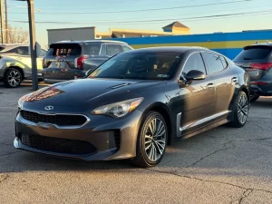 2019 Kia Stinger in a dynamic driving pose, showcasing its sleek design and sporty performance on the open road.