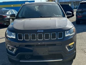 A 2018 Jeep Compass parked on a scenic road, showcasing its sleek design and rugged off-road capabilities.