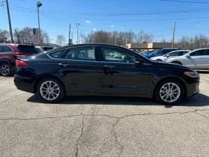 2020 Ford Fusion Hybrid in a sleek silver exterior, showcasing its modern design and hybrid efficiency on the road.