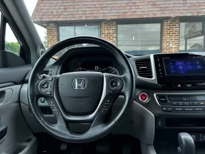 A sleek 2017 Honda Pilot SUV in a neutral setting, showcasing its robust design and spacious family-friendly appeal.