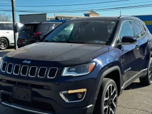 A 2018 Jeep Compass parked on a scenic road, showcasing its sleek design and rugged off-road capabilities.