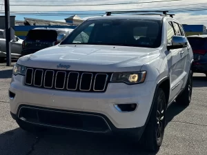 2019 Jeep Grand Cherokee parked on a scenic landscape, showcasing its sleek design and rugged off-road capability.