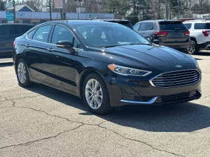 2020 Ford Fusion Hybrid in a sleek silver exterior, showcasing its modern design and hybrid efficiency on the road.