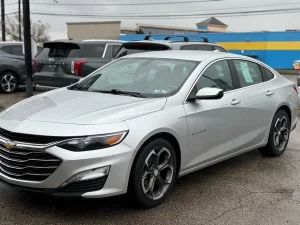 The 2022 Chevrolet Malibu LT parked on a scenic road, showcasing its modern design and stylish exterior details.