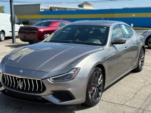 A sleek 2019 Maserati Ghibli SQ4 GranSport in gray, showcasing its elegant design, bold curves, and luxurious appeal against a clean background.