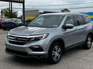 A sleek 2017 Honda Pilot SUV in a neutral setting, showcasing its robust design and spacious family-friendly appeal.