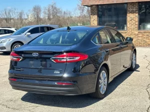 2020 Ford Fusion Hybrid in a sleek silver exterior, showcasing its modern design and hybrid efficiency on the road.