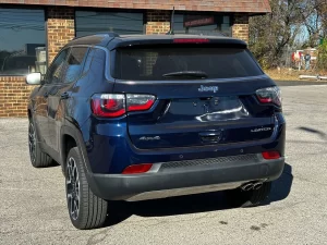 A 2018 Jeep Compass parked on a scenic road, showcasing its sleek design and rugged off-road capabilities.