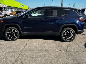 A 2018 Jeep Compass parked on a scenic road, showcasing its sleek design and rugged off-road capabilities.