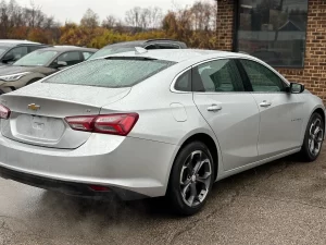 The 2022 Chevrolet Malibu LT parked on a scenic road, showcasing its modern design and stylish exterior details.