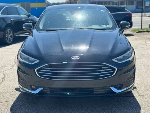 2020 Ford Fusion Hybrid in a sleek silver exterior, showcasing its modern design and hybrid efficiency on the road.