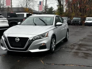 2020 Nissan Altima parked on a scenic road, showcasing its sleek design and modern features.