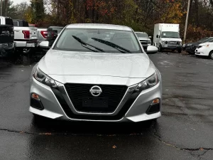 2020 Nissan Altima parked on a scenic road, showcasing its sleek design and modern features.