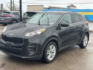 A 2018 Kia Sportage LX parked, showcasing its sleek design, modern features, and stylish wheels in a dynamic setting.