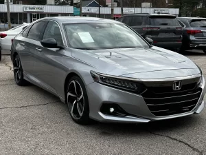 A sleek 2021 Honda Accord in a scenic outdoor setting, showcasing its modern design, bold grille, and premium features.