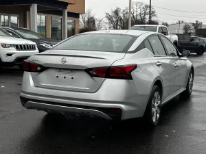 2020 Nissan Altima parked on a scenic road, showcasing its sleek design and modern features.