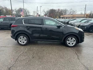 A 2018 Kia Sportage LX parked, showcasing its sleek design, modern features, and stylish wheels in a dynamic setting.