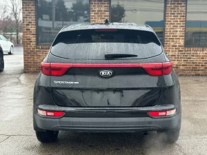 A 2018 Kia Sportage LX parked, showcasing its sleek design, modern features, and stylish wheels in a dynamic setting.