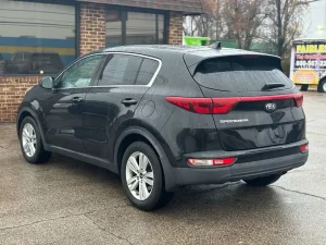 A 2018 Kia Sportage LX parked, showcasing its sleek design, modern features, and stylish wheels in a dynamic setting.